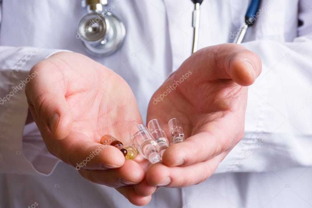 Doctor, pharmacist or scientist holds in open palms ampoule with  necessary effective drugs to treat serious diseases such as cancer, providing or giving hope to patients to cure  disease closeup
