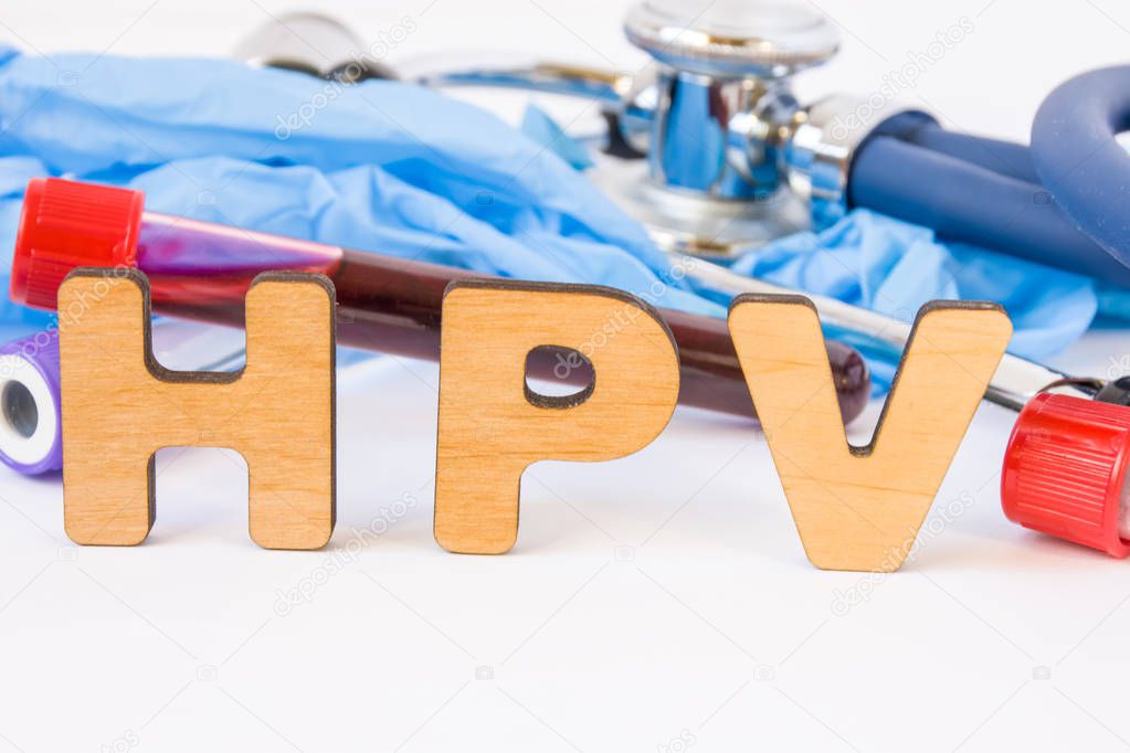 Abbreviation or acronym of HPV, in laboratory, scientific, research or medical practice means human papilloma virus, is in foreground with laboratory test tubes, medical stethoscope and gloves