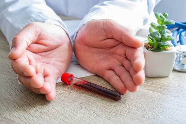 Hastalıklara, patolojilere, onkoloji konsepti fotoğraflarına karşı kan sağlığında koruma, tedavi, önleme ve himaye sağlığı. Doktor eli kanlı bir laboratuvar tüpüyle çevrili.