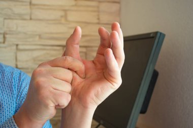 Baş parmağında ağrı ya da spazmın konsept fotoğrafı. Erkek baş parmağını avucunun içinde tutar, hangi kaslar spazm geçirir ya da eklemleri ağrır. Nöroloji, romatoloji veya travmatoloji için fotoğraf kullanımı