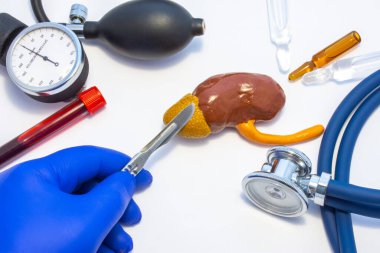 Adrenalin ameliyatı, adrenalektomi ameliyatı ya da ameliyatın konsept fotoğrafı. Elinde neşter olan doktor, tıbbi alet çantasının yanında bulunan insan adrenalini figüründe kesik atıyor. Stetoskop.