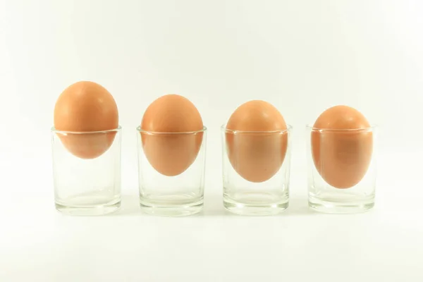 Cuatro huevos en un vaso corto aislado sobre fondo blanco —  Fotos de Stock