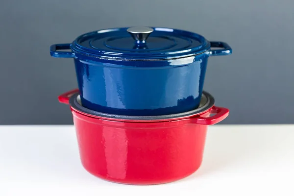 Hornos Holandeses Cubiertos Hierro Fundido Esmaltado Rojo Azul Sobre Fondo — Foto de Stock