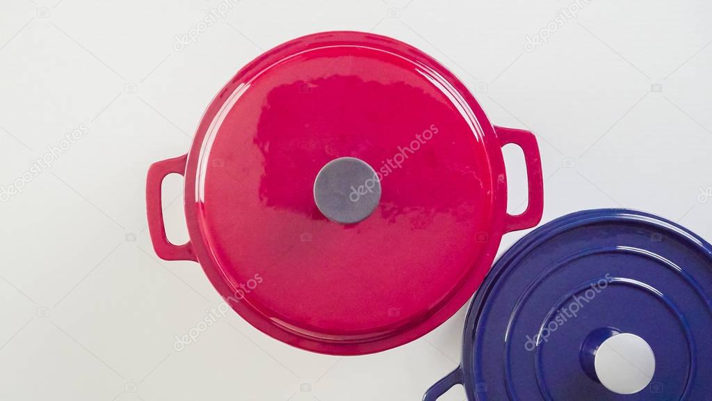 Brand new enameled cast iron covered dutch oven on a white background.