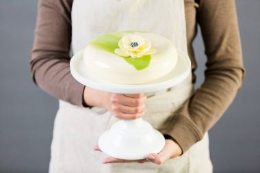 Gurme mousse kek bir beyaz pasta stand üzerine tutarak Pastre Şef.