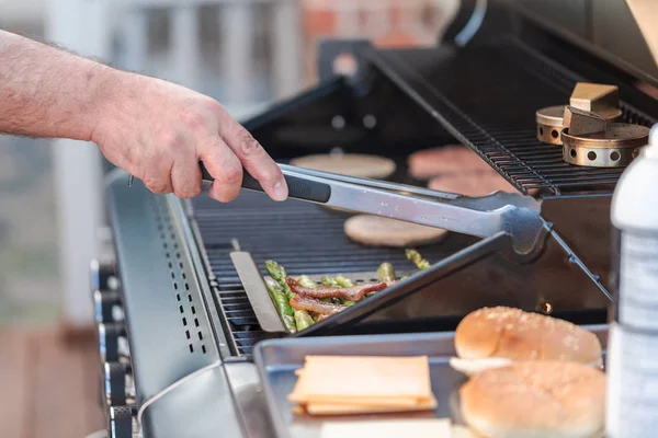 Cocinar hamburguesas en la parrilla de gas al aire libre —  Fotos de Stock