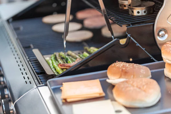 Vaření na venkovní plynový gril hamburgery — Stock fotografie