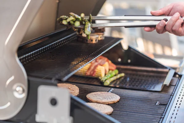 Cooking hamburgers on outdoor gas grill — Stock Photo, Image