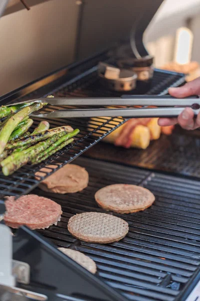Vaření na venkovní plynový gril hamburgery — Stock fotografie
