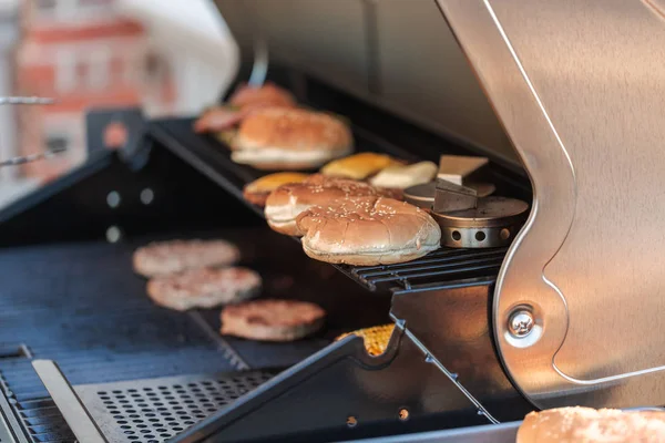 Vaření na venkovní plynový gril hamburgery — Stock fotografie