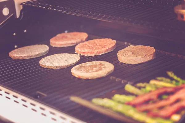 Step by step. Cooking burgers on outdoor gas grill in the Summer.