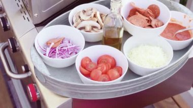 Açık hava ızgarasında pizza pişirmek.