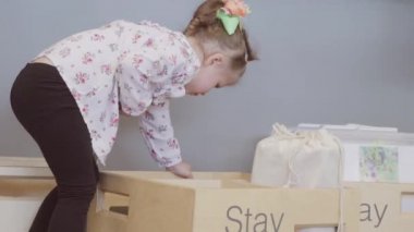 Küçük kız yerel kütüphanede oyuncaklar ile oynama