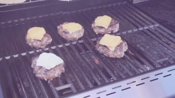 屋外のガスのグリルの上の古典的な牛肉のハンバーガーを調理 — ストック動画