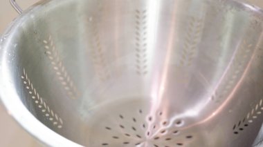 Paslanmaz çelik kevgire bulanmış çekirdeksiz üzümler..