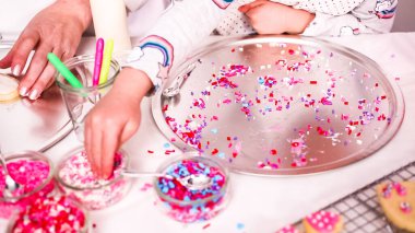 Adım adım. Küçük kız Kraliyet krema ve şeker ile şekerli kurabiye Sevgililer günü için decarting.