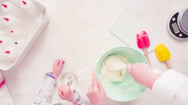 Düz yatıyordu. Adım adım. Şekerli kurabiye süslemek için royal Icing karıştırma.