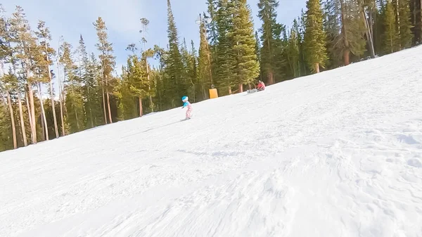 丘を下ってアルプス山脈でスキーをする方法を学ぶ少女 — ストック写真