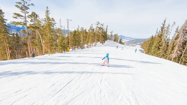 stock image Little girl learning how to ski down the hill on alpine mountains.