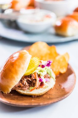 Barbekü, brioche çörekleriyle küçük hamburgerler şeklinde domuz sandviçi çekti..