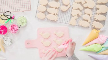 Adım adım. Düz yatıyordu. Paskalya şekerli kurabiyeleri dönüşümlü kremayla süslemek.