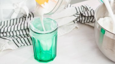 Adım adım. Düz yatıyordu. Paskalya şekeri pişirmek için kraliyet kremasını karıştırıyorum..