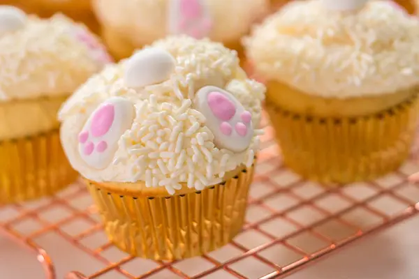 Menghias Cupcakes Vanili Dengan Buttercream Icing Putih Dan Telinga Kelinci — Stok Foto