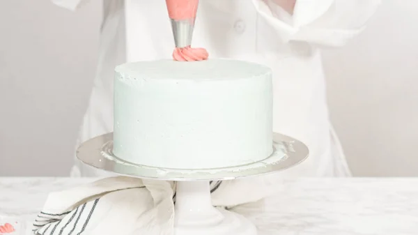 丸三層のバニラケーキの上にバタークリームロゼットをパイピング — ストック写真