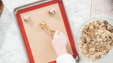 Adım adım. Düz yatıyordu. Hamur kepçesiyle ev yapımı çikolatalı kurabiyeler pişiriyorum..