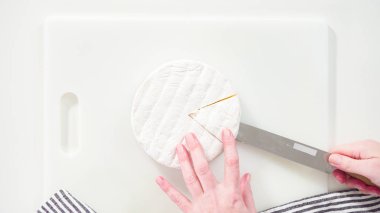 Düz yatıyordu. Beyaz arka planda büyük bir dilim gurme peyniri dilimliyorum..