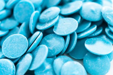 Çikolata şekillerini eritmek için mavi yuvarlak çikolata parçaları.