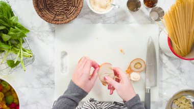 Düz yatıyordu. Adım adım. Tek demlik makarna tarifi yapmak için beyaz bir kesim tahtasıyla sebze kesmek..