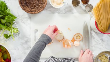 Düz yatıyordu. Adım adım. Tek demlik makarna tarifi yapmak için beyaz bir kesim tahtasıyla sebze kesmek..