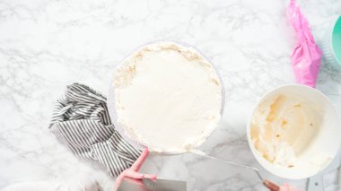 Düz yatıyordu. Adım adım. Beyaz İtalyan kremalı, yuvarlak funfetti keki..