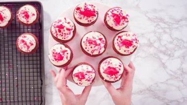 Düz yatıyordu. Adım adım. Mermer pasta standında kırmızı kadife kekler düzenlemek..