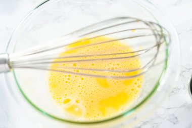 Vanilyalı kek pişirmek için cam bir kasede yumurta çırpıyorum..