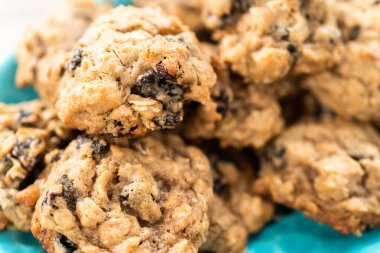 Mavi tabakta taze pişmiş yulaf ezmeli kuru üzümlü kurabiye..