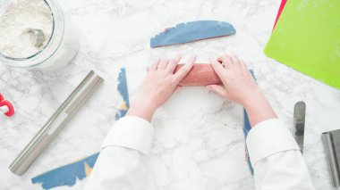 Adım adım. Düz yatıyordu. Kırmızı, beyaz ve mavi fırıldak şekerli kurabiyeler pişirmek için hamuru yuvarlıyor..