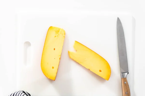 Grande Fatia Queijo Gouda Defumado Uma Placa Corte Branca — Fotografia de Stock