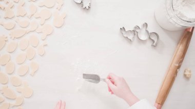 Adım adım. Düz yatıyordu. Paskalya şekilli kurabiye kesicilerle şekerli kurabiye hamuru kesiyorum..