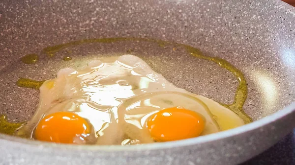 Frying organic egg in olive oil on frying pan.