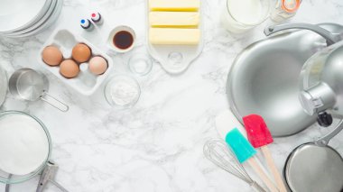 Adım adım. Düz yatıyordu. Üç katlı vanilyalı kek pişirmek için mutfak mikserinin malzemelerini karıştırıyorum..