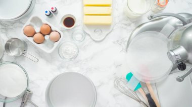 Adım adım. Düz yatıyordu. Üç katlı vanilyalı kek pişirmek için tereyağlı kek tavaları yağlamak..