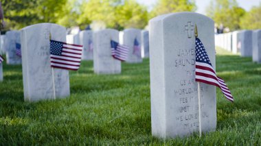 Denver, Colorado, ABD-26 Mayıs 2019 - Anma Günü 'nde Fort Logan Ulusal Mezarlığı' nda beyaz mermer mezar taşlarının yanında küçük Amerikan Bayrakları.