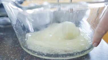 Kahvaltıda taze waffle yapmak için cam karıştırma kabında ev yapımı waffle hamuru hazırlıyorum..