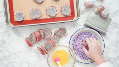 Adım adım. Düz yatıyordu. Kırmızı, beyaz ve mavi fırıldak şekerli kurabiyelerin kıvrımlı kenarları.