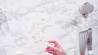 Düz yatıyordu. Adım adım. Mermer tezgahın üzerindeki beyaz fondanla kar tanelerini keserek..