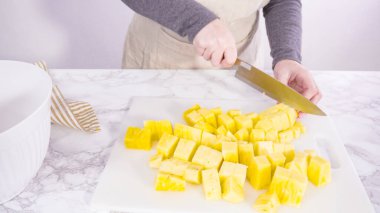 Adım adım. Beyaz bir kesme tahtasıyla ananas kesmek.