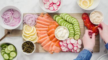 Düz yatıyordu. Adım adım. Füme somon ve taze sebze ile simit brunch kurulu Montajı.