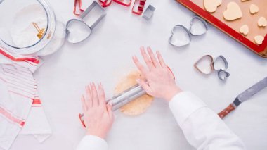 Düz yatıyordu. Adım adım. Metal oklava ile şeker kurabiye hamuru haddeleme.